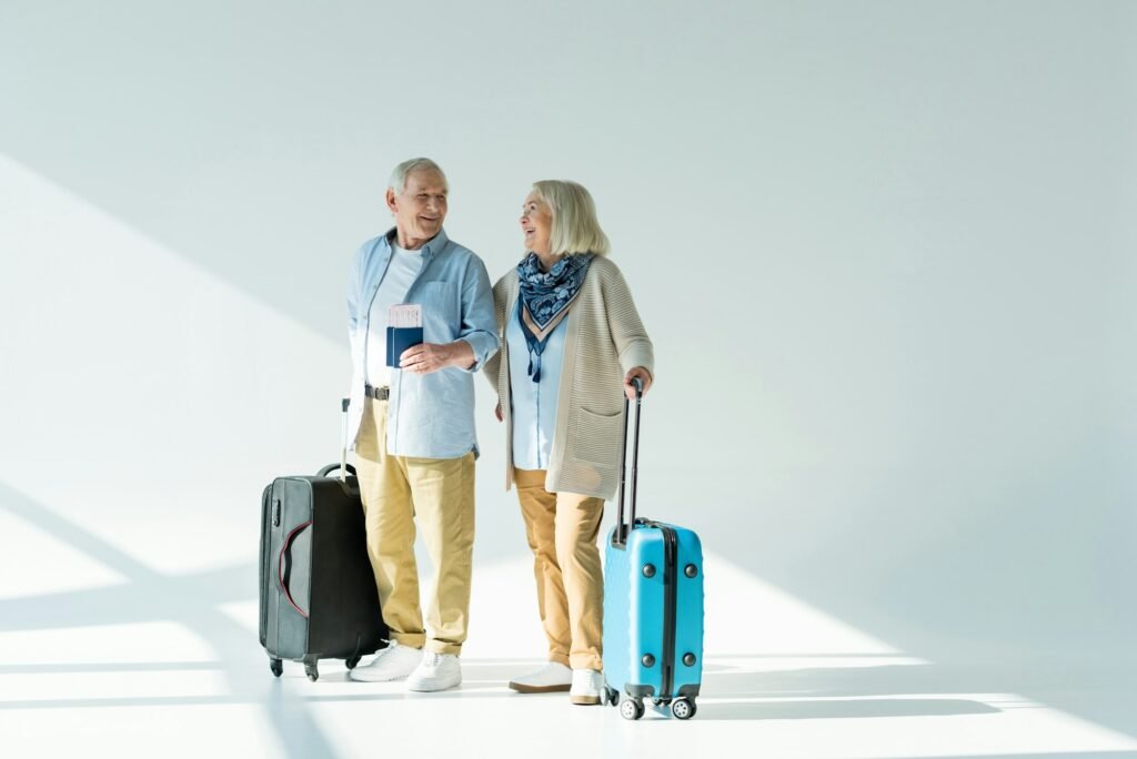 happy senior couple with traveling bags, passports and tickets, traveling concept