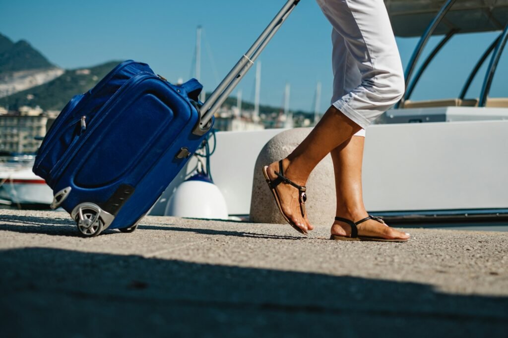 Tourist woman with travel bag walking along the pier